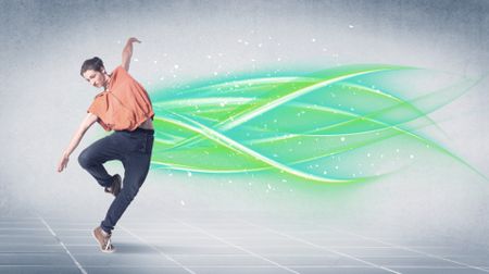 A good looking fresh street dancer dancing in front of grey background with white and bright, colorful green lines concept