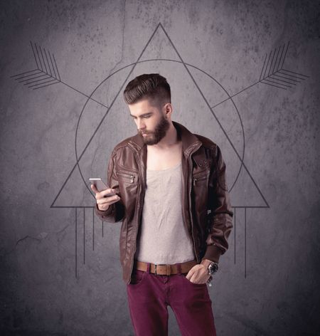 A young hipster male in modern clothes standing in front of an urban wall with modern sign illustration concept