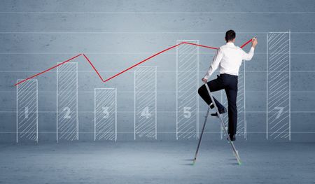 A man in elegant suit standing on a small ladder and drawing a chart on blue wall background with numbers, lines, blocks,