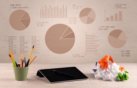 Graphic business office desk with pie charts and graphs on the brown sepia background wall