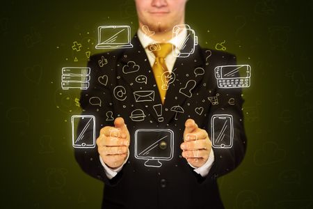 Businessman holding icons related to devices and communication