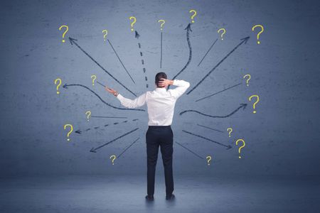 Businessman standing in front lines and question mark signs concept on background