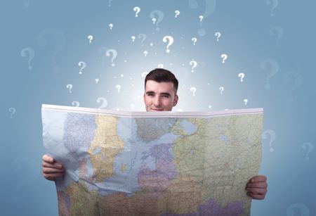 Handsome young man holding a map with white question marks above his head