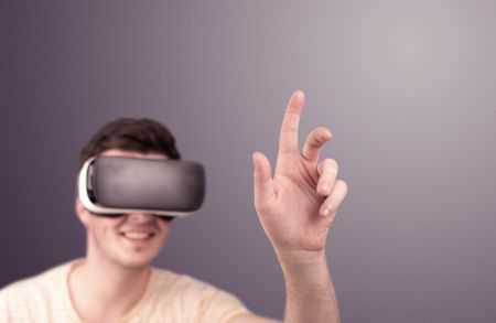 Young impressed man wearing virtual reality goggles