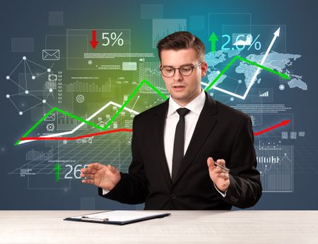 young-handsome-businessman-sitting-desk-stocks-644334049 Young handsome businessman sitting at a desk with stocks and progress charts behind him