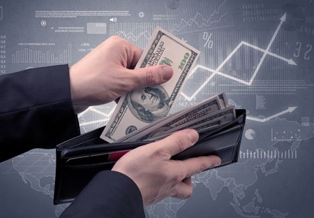 Businessman's hand takes out dollar from wallet with finance graphic on the background