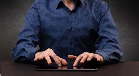 Businessman in suit typing with dark background