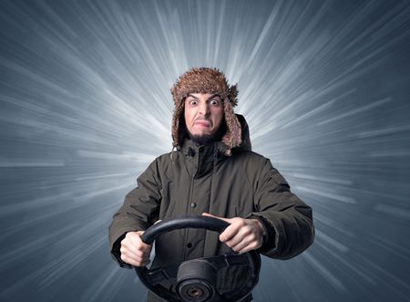 Young man holding black steering wheel with white lines behind him 