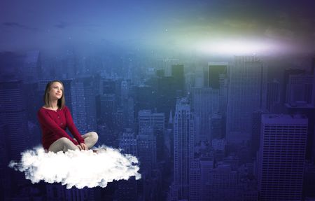 Caucasian woman sitting on a white fluffy cloud above the big city wondering