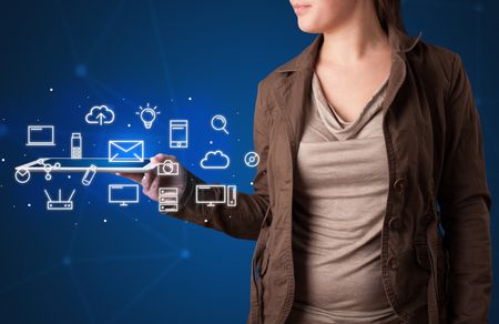 Casual young woman holding tablet with multimedia icons 