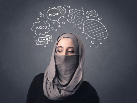 Young muslim woman wearing niqab with drawn speech bubbles above her head 