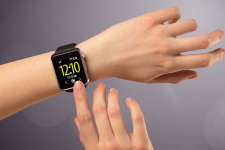 Naked female hand with smart wristwatch and digital clock on the screen 