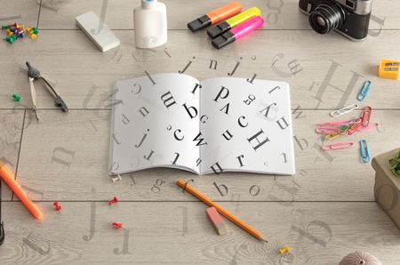 Open notebook on the floor with office instruments nearby and letters on it