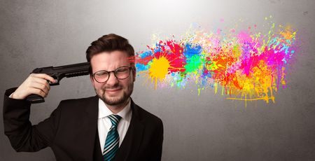 Man shoots his head with gun and colorful splotch are coming out from his head