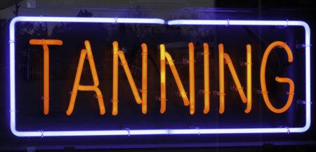 Neon sign in window of tanning salon