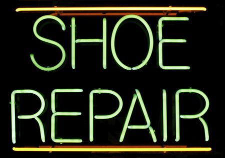 Neon sign in window of shoe repair shop