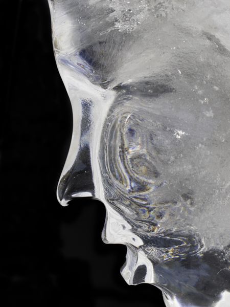Profile of human face in ice (isolated on black)