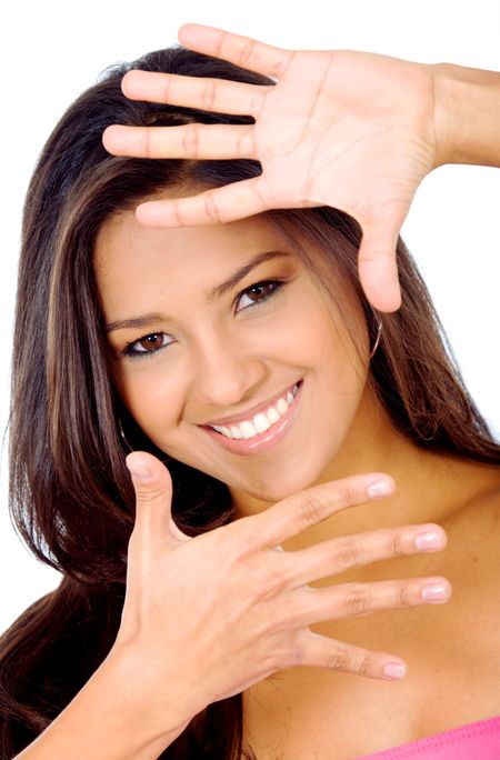 casual girl smiling and doing a handframe on her face isolated over a white background
