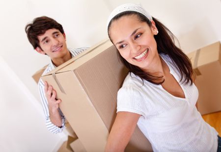 Couple with cardboard boxes moving into a new house