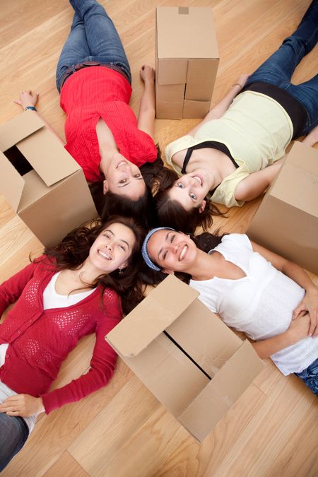Girls tired of packing lying on the floor with boxes