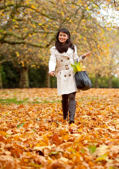 Autumn woman walking outdoors at the park
