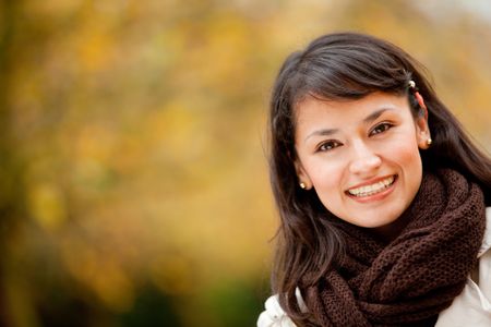 Portrait of an autumn woman smiling at the park