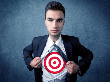 Businessman tearing his shirt off with target sign symbol on his chest concept on background