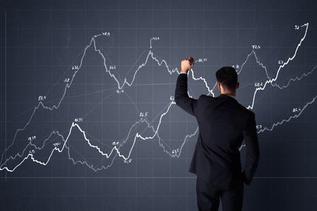 Young businessman in black suit standing in front of a progress chart