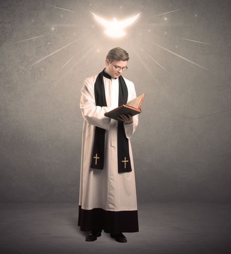 A holy priest reading a prayer from the holy bible with illustrated glowing angel above his head concept.