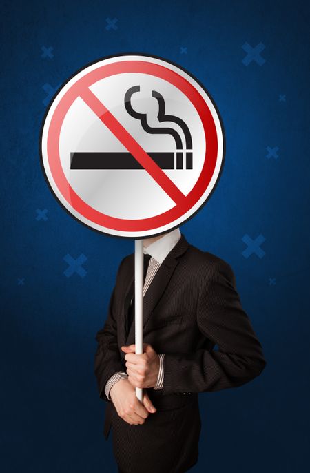 Smart businessman holding round sign with no smoking graphic