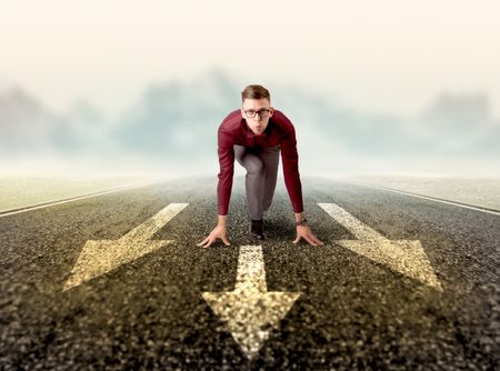 Young determined businessman kneeling before three arrows 