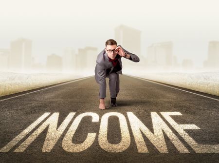 Young determined businessman kneeling before income sign