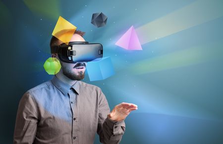 Amazed businessman with virtual reality colorful geometric shapes in front of him