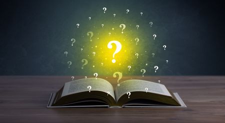 Yellow question marks hovering over open book