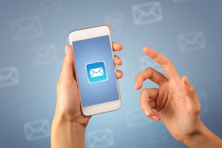 Female fingers touching smartphone with mail icon on it