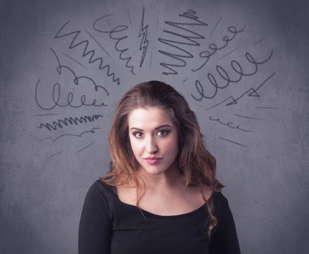 A cute female student making funny face expressions with pressure and problems in her head illustrated by drawn lines, marks and spirals on the urban wall background concept.
