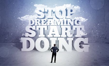 A lazy sales person standing in emty space with huge block letters illustration saying stop dreaming start doing and clouds concept