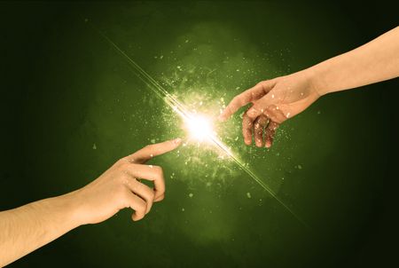 Two naked male hands about to touch, lighting the spark with modest explosion in front of green background concept