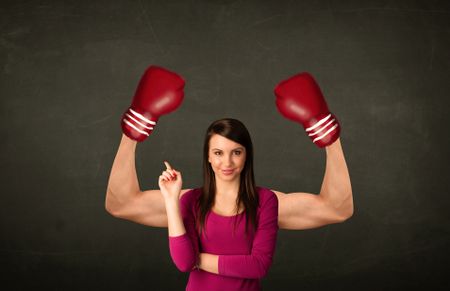 Pretty young woman with strong and muscled boxer arms concept