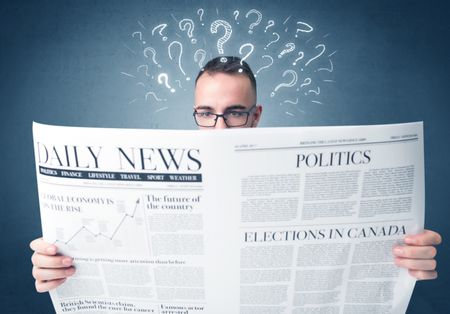 Young confused businessman reading daily newspaper with question marks above his head