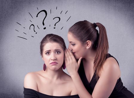 A teenager girl looking confused with drawn question marks above the head, while a girlfriend whispers something in her ear concept.