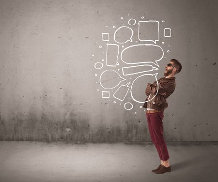 A comic hipster guy shouting in front of grey urban concrete wall with drawn empty text bubbles around his mouth concept