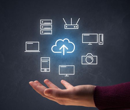 Cloud and computing related icons hovering over young hand 