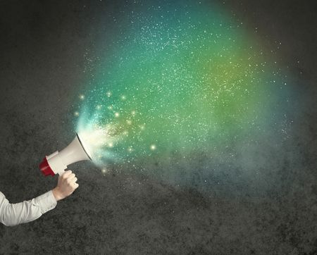 Caucasian business hand holding megaphone with white sparkles on a grunge background