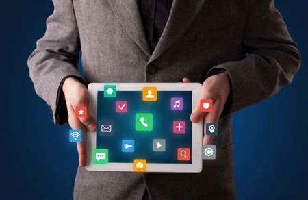 Casual businessman holding tablet with colorful applications