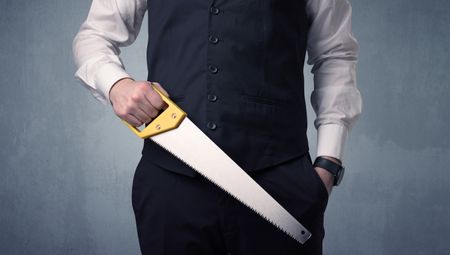 Young, handsome, cute businessman holding tool with grey background