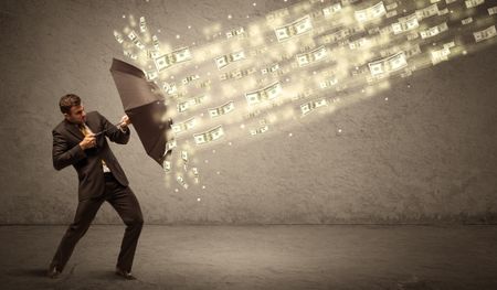 Business man holding umbrella against dollar rain concept on grungy background