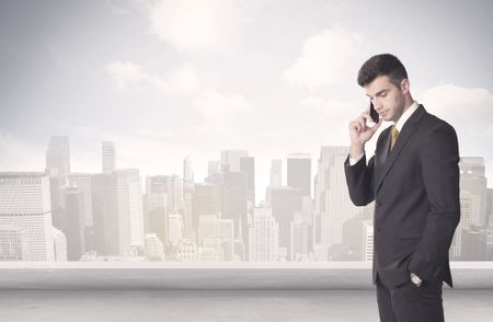 A young adult businessman standing in front of city landscape with skyscraper buildings and clouds concept