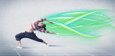 A good looking fresh street dancer dancing in front of grey background with white and bright, colorful green lines concept