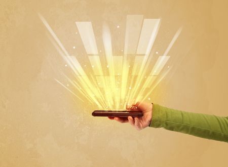 A caucasian hand holding a tablet phone with light beams and information escaping the device illustration concept